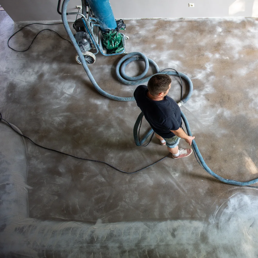 Floor preparation specialists grinding and smoothing a concrete subfloor