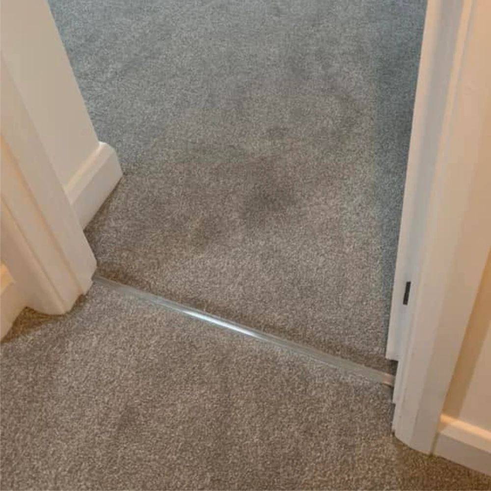Trimmed internal door providing clearance above newly fitted grey carpet