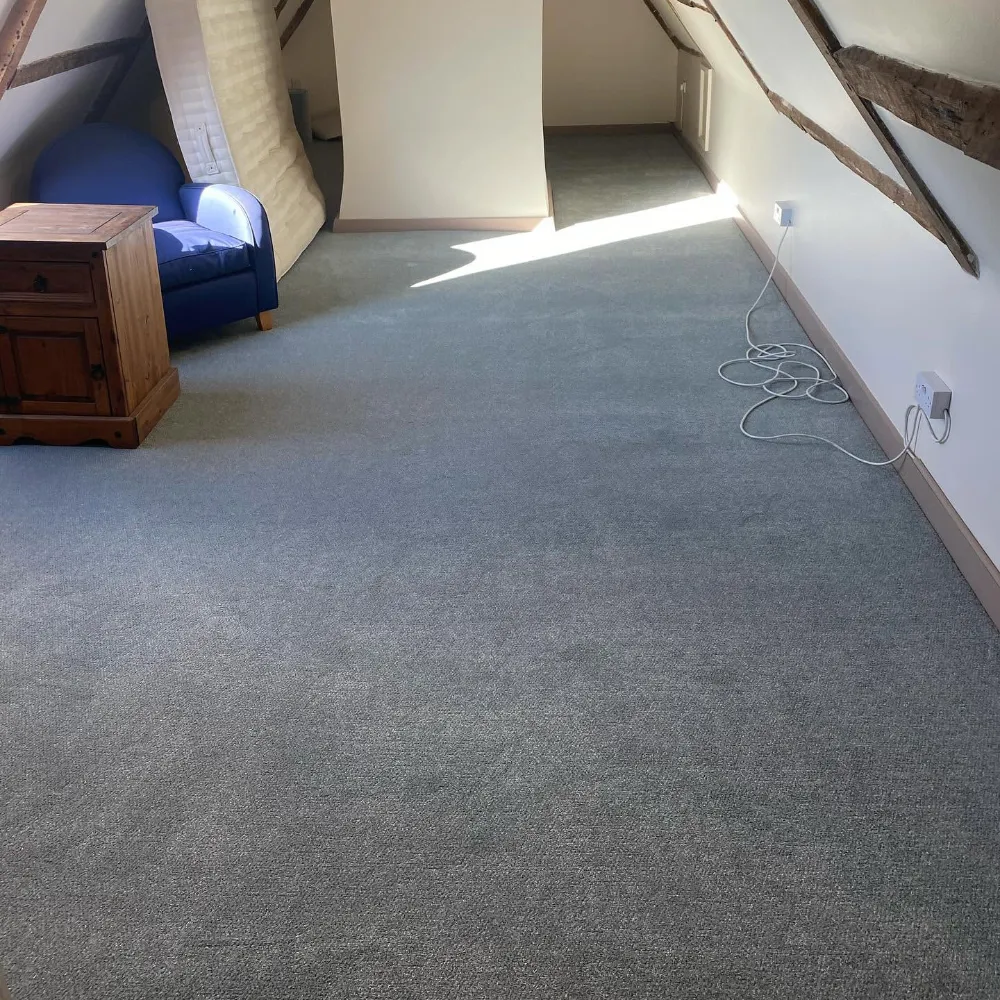 Grey carpet fitted in a loft room with exposed wooden beams
