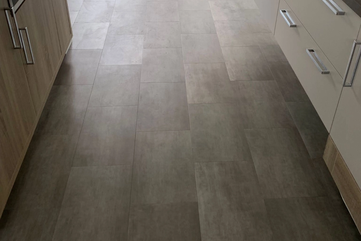 Grey stone-effect vinyl flooring fitted throughout a modern kitchen