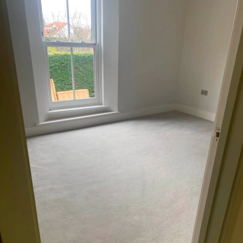 Light grey carpet fitted in a bright bedroom