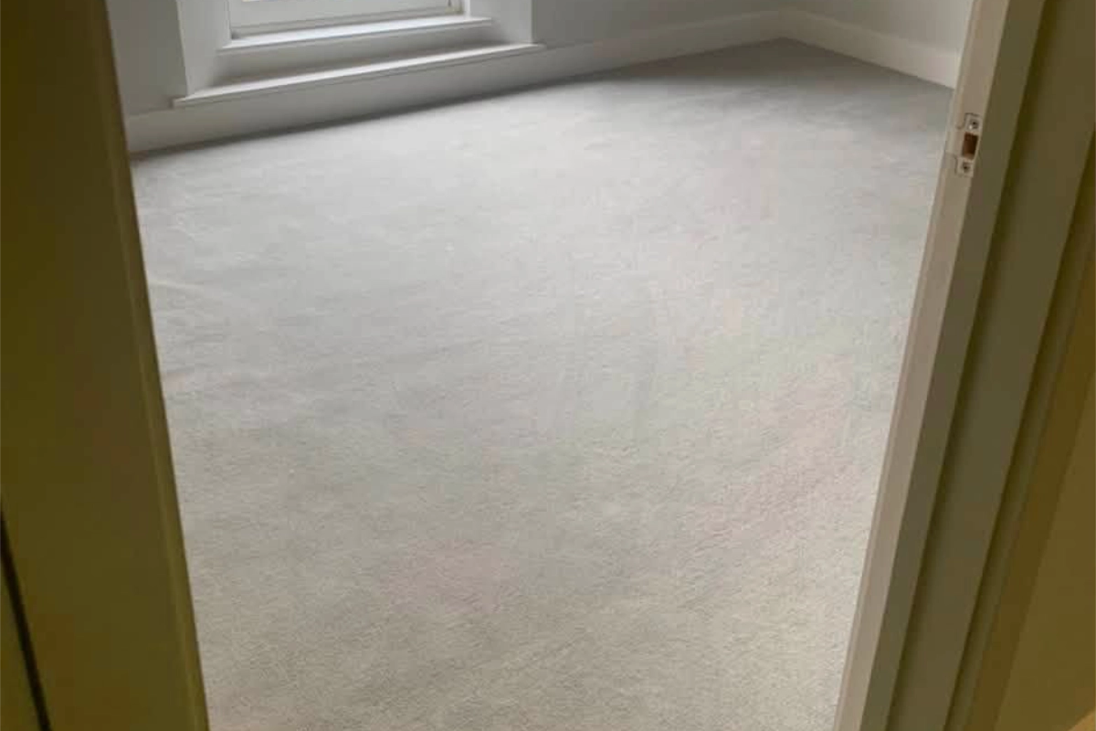 Light grey carpet fitted in a bright bedroom