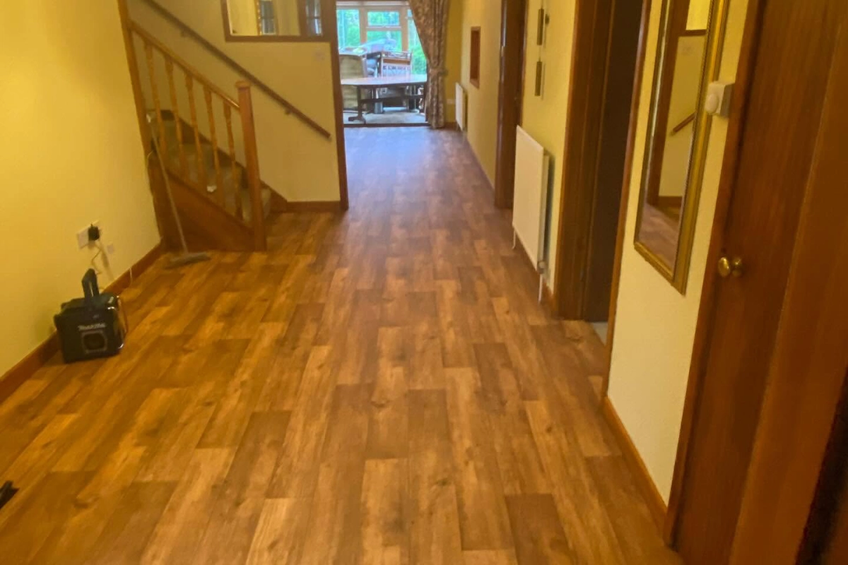 Wood-effect vinyl flooring fitted throughout a hallway and entrance area