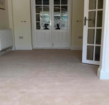 Beige fitted carpet in a bright residential living room