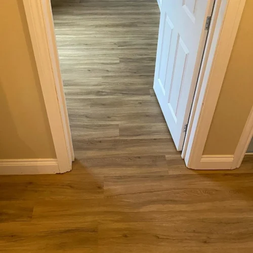 Oak-effect flooring fitted through a residential hallway and adjoining room